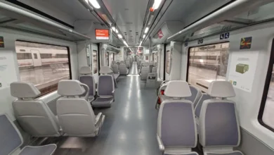 Primer plano de las ruedas y los componentes metálicos de un tren de Cercanías sobre las vías ferroviarias.