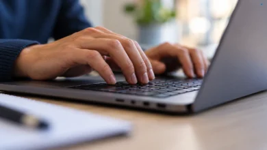 Primer plano de un teclado de ordenador y una pantalla desenfocada que representan la tramitación electrónica municipal.