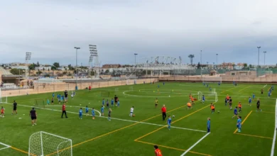 Campo de fútbol de Bahía Sur con césped artificial y jóvenes deportistas realizando actividades deportivas