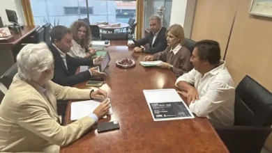Reunión institucional en una sala con seis personas alrededor de una mesa de trabajo